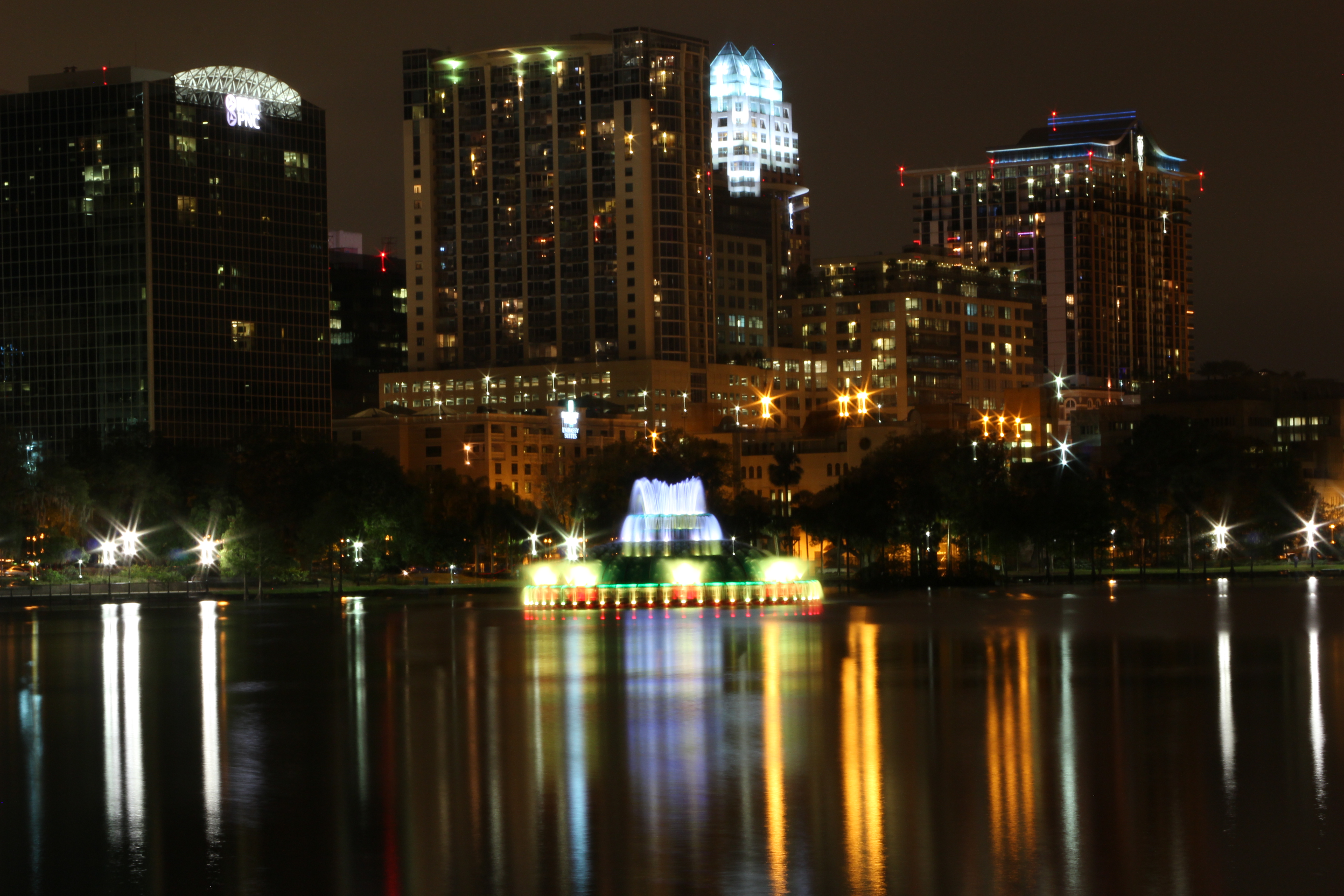 Photograph of the Lake Eola fountain with the Orlando skyline in the background, at night